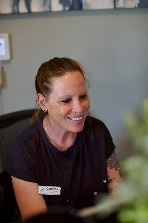Cathrine, a Hope Center team member, smiling at the front desk
