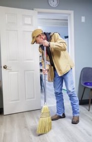 A neighbor sweeping a hallway at the Hope Center