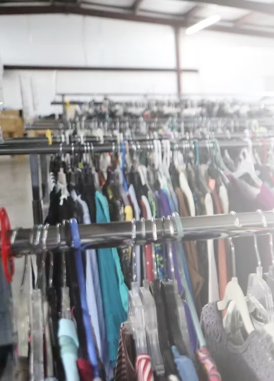 Long racks of clothing inside the thrift store